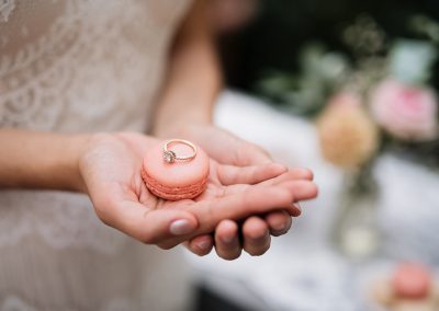 Macaron mit Ring liegt in der Hand der Braut